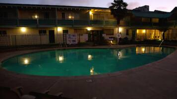 Una piscina al aire libre, tumbonas