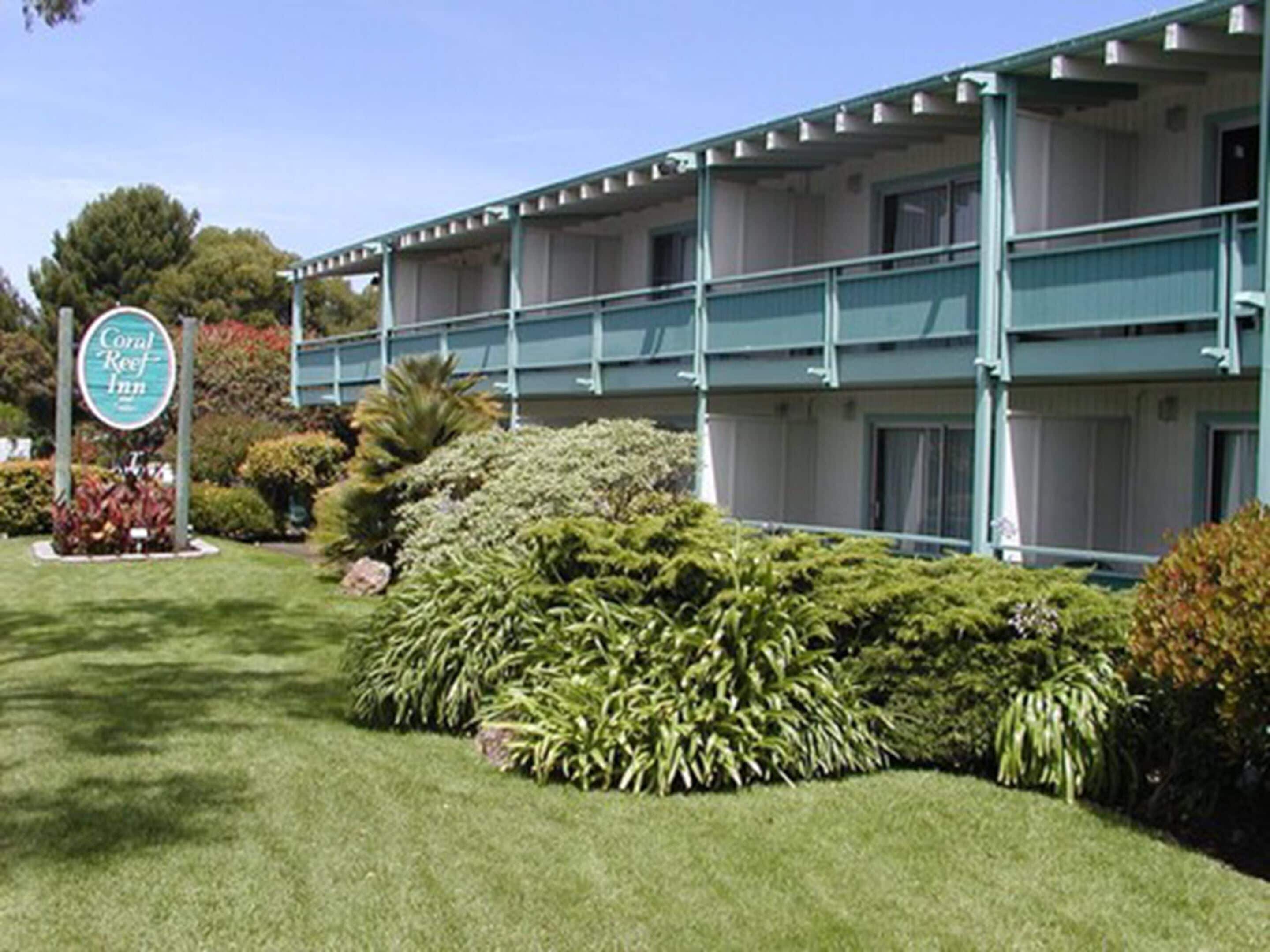 Un hôtel à la structure à deux étages, doté d’un espace extérieur couvert et d’un aménagement paysager bien entretenu.