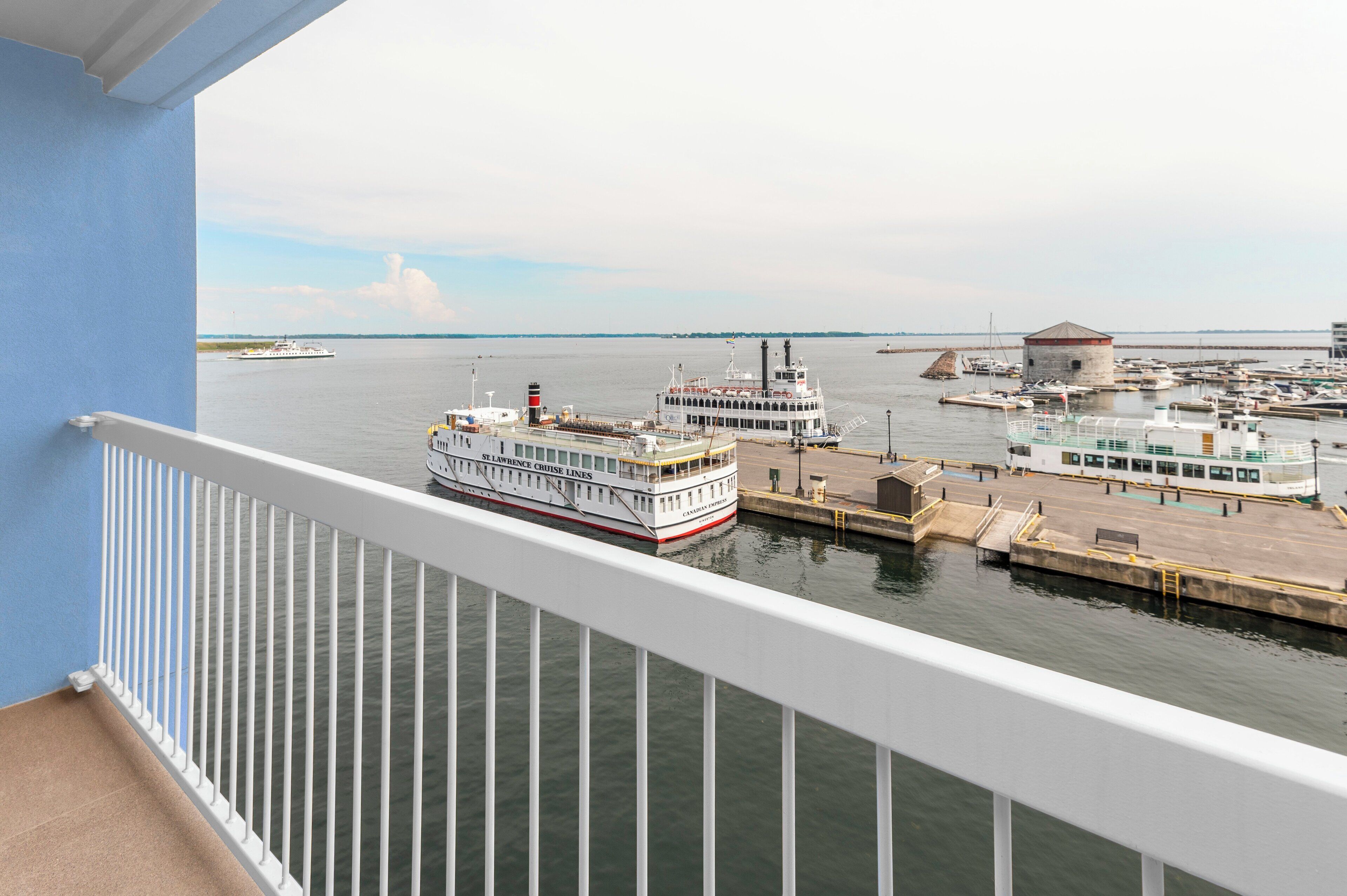A ferry dock with a white and red ferry named "St. Lawrence Cruise Lines" and a small building in the background.