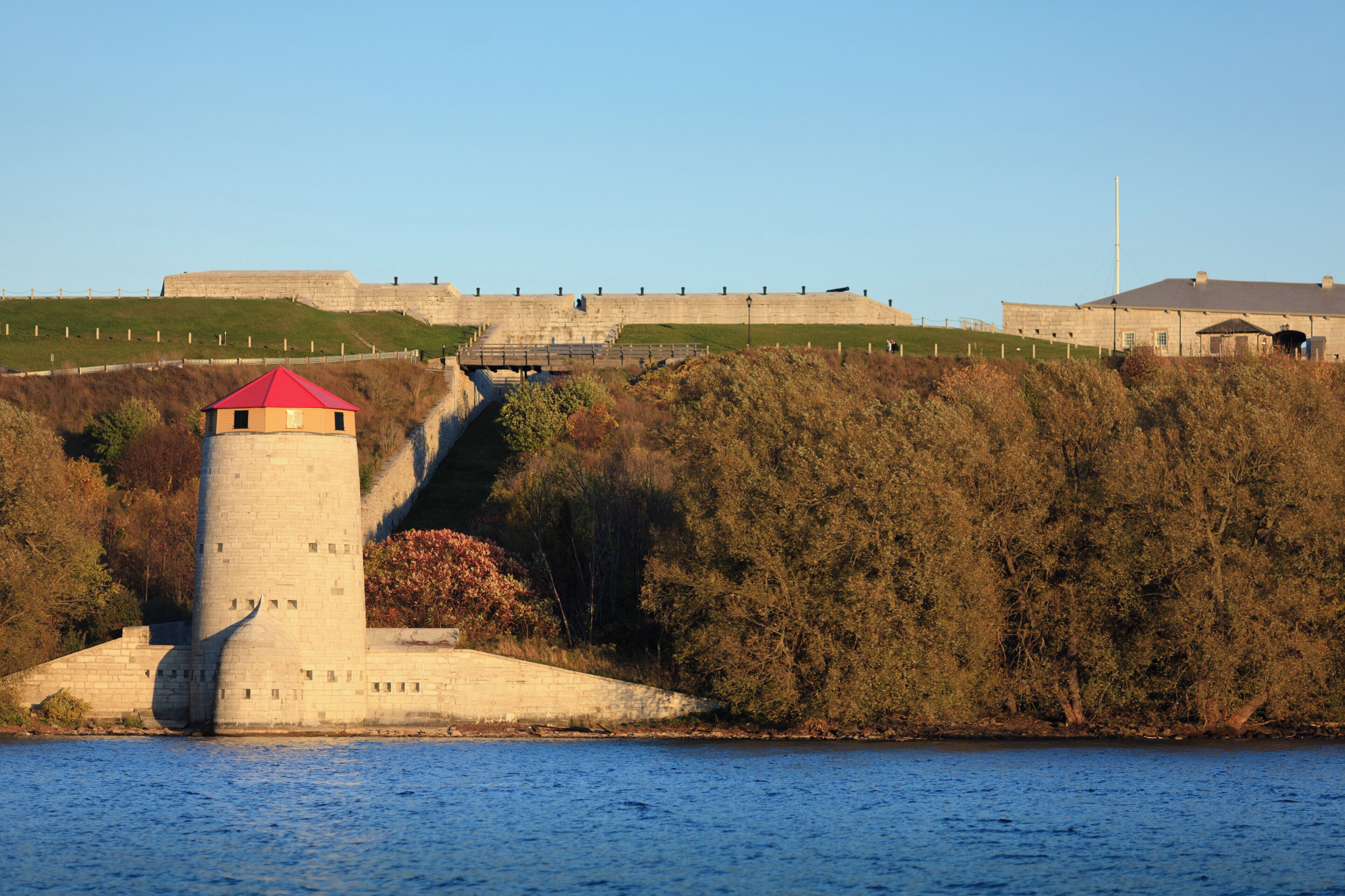 A coastal fortification with a prominent tower and a large wall.