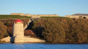 A coastal fortification with a prominent tower and a large wall.