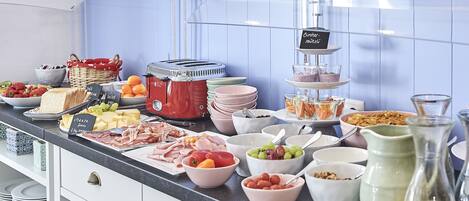 A buffet with various food items and a coffee station.
