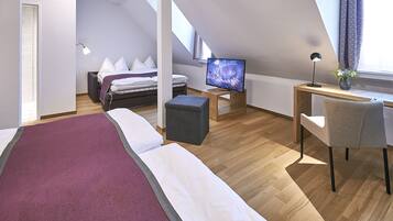 Un dormitorio moderno con cama, escritorio, silla, televisor y ventana con cortinas.