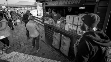 A food stall with a sign reading "HEISSI MARRONI" selling various food items.
