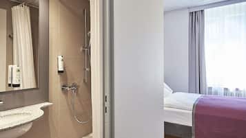 A modern bathroom with a shower, a sink, and a mirror.