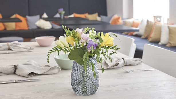 A dining table with a vase of flowers, a bowl, and a napkin. - Hotel Central Luzern (Lucerne)