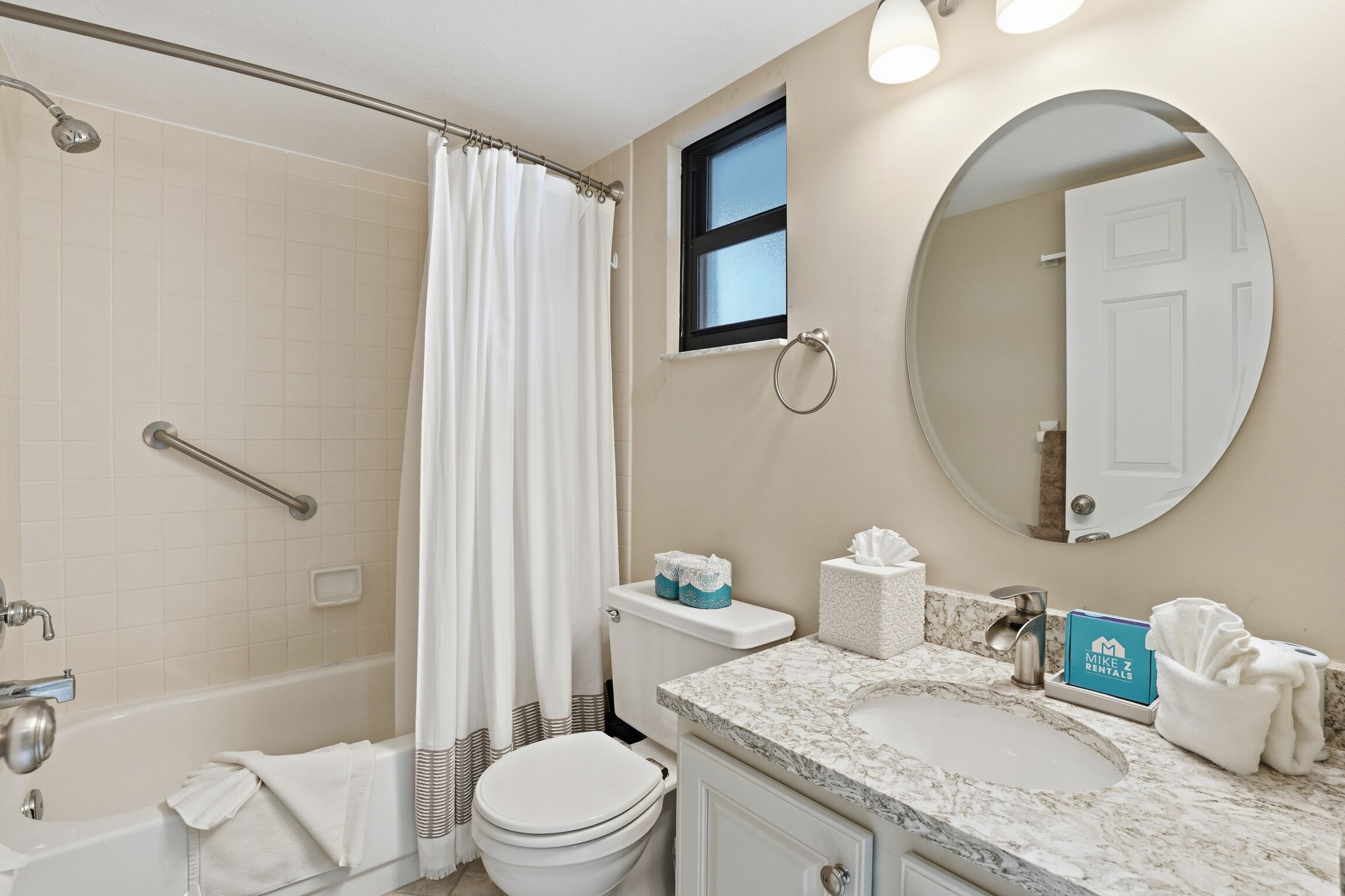 Une salle de bain équipée d’une douche, de toilettes, d’un lavabo et d’un miroir.