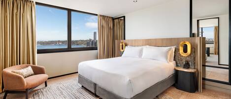 A modern hotel room with a large bed, a view of the city, and a cityscape through the window.