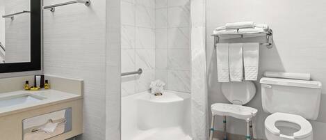 Un baño moderno con bañera, inodoro y zona de ducha.