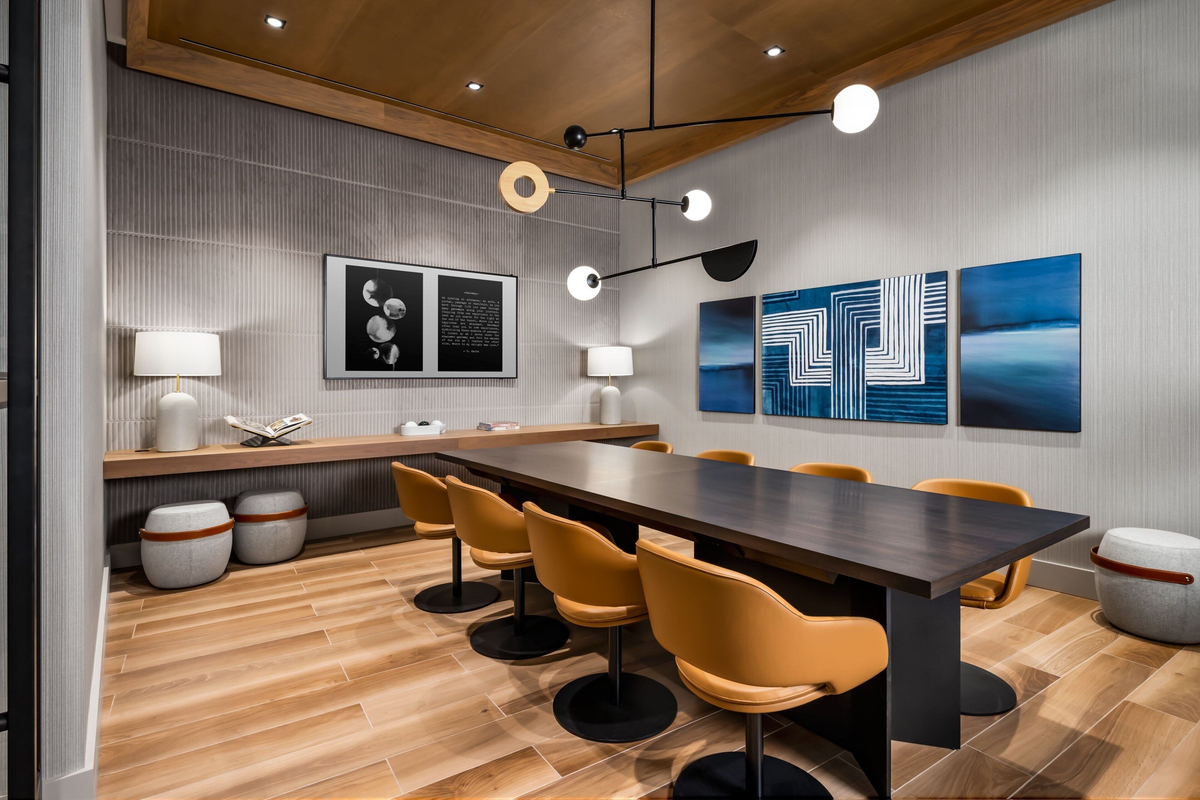 A modern conference room with a long table, yellow chairs, and a wooden ceiling.