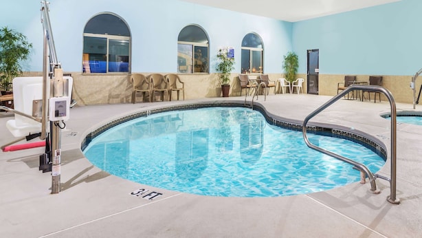 Una piscina interior con agua cristalina, rodeada de tumbonas y una zona de estar.