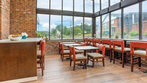 A restaurant with brick walls, large windows, and wooden tables and chairs. - Best Western Danbury/Bethel (Bethel)