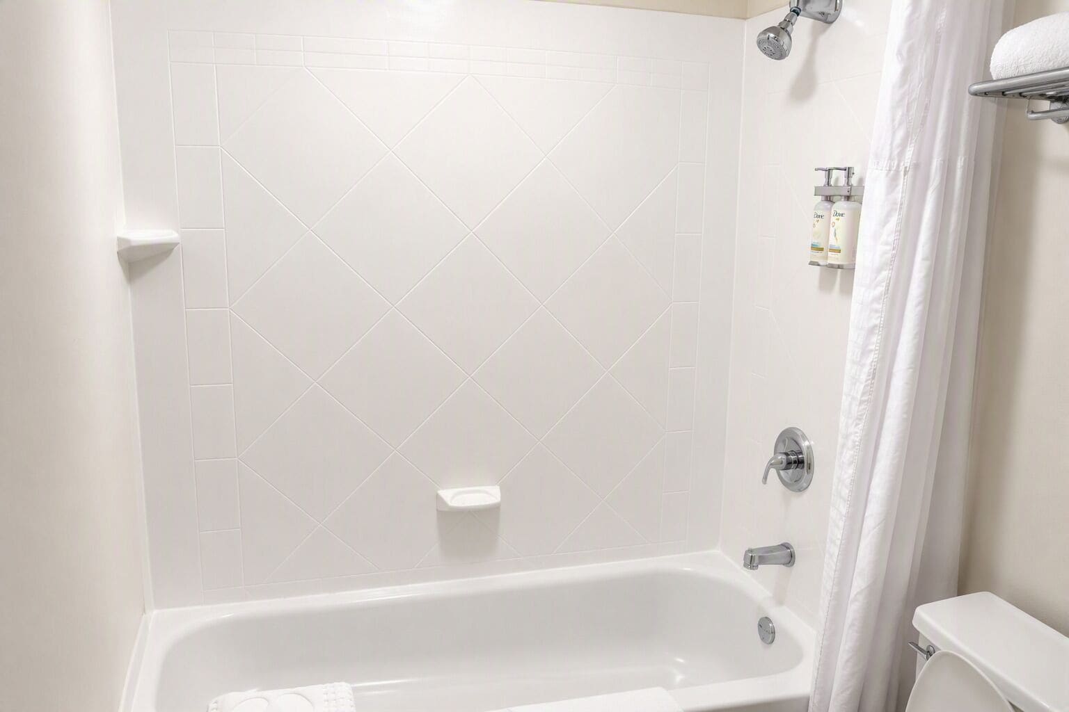 A bathroom with a white bathtub, a shower, and a toilet.