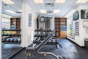 A gym with weightlifting equipment, mirrors, and informational posters. - Best Western Premier Chateau Granville Hotel & Suites & Conf. Centre (Vancouver)