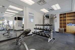 A gym with exercise equipment, a mirror, and a wall with informational posters. - Best Western Premier Chateau Granville Hotel & Suites & Conf. Centre (Vancouver)