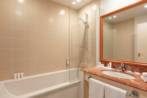 Enjoy a relaxing soak in the spacious bathtub and glass-enclosed shower.