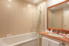 Enjoy a relaxing soak in the spacious bathtub and glass-enclosed shower.