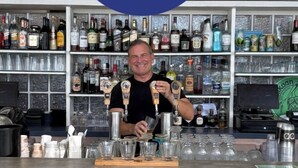 A bartender at Seaview Beach Hotel in St. Maarten, with a bar stocked with various liquor bottles and glasses.