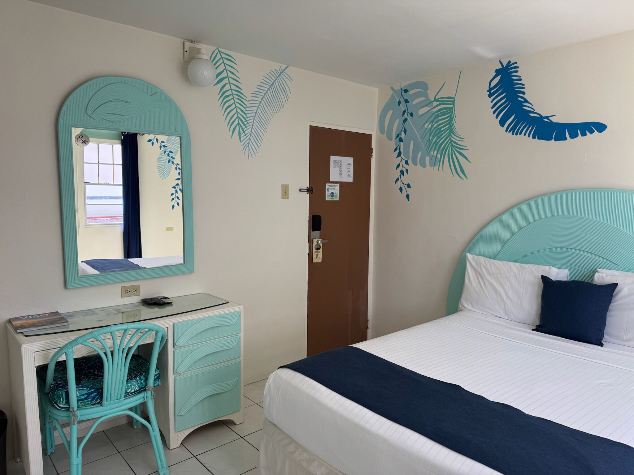 Une chambre à coucher avec un lit, un bureau, une chaise et une porte.