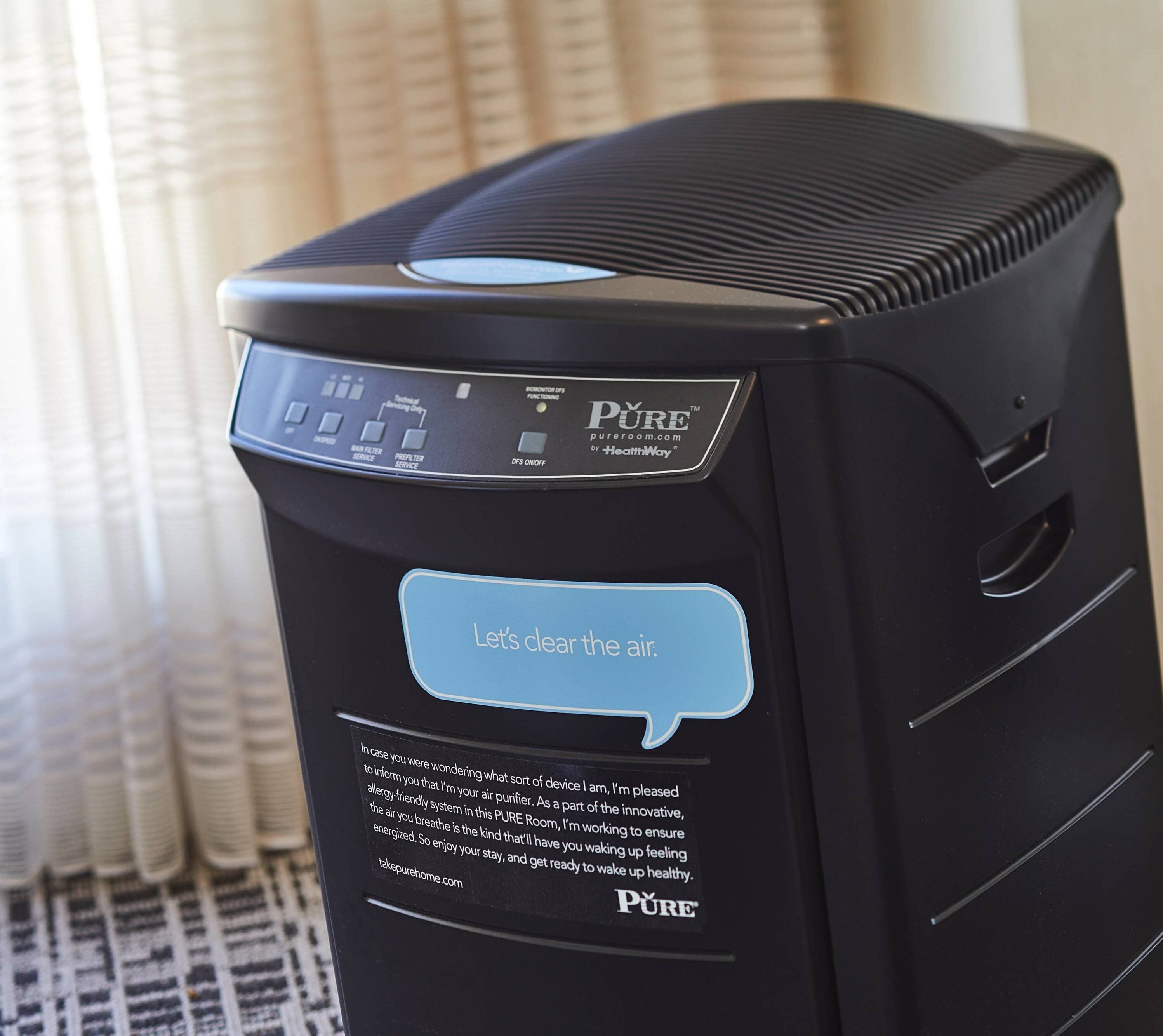 Un purificateur d’air noir doté d’un panneau de commande et d’une bulle de dialogue indiquant : « Purifions l’air. »