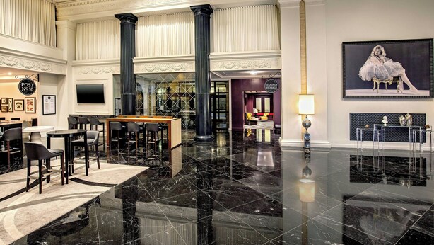 Un hall d’entrée spacieux, doté d’un sol en marbre noir poli, d’une table de billard et d’un espace détente avec des fauteuils et des tables.