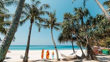 On the beach, white sand, sun loungers, beach umbrellas