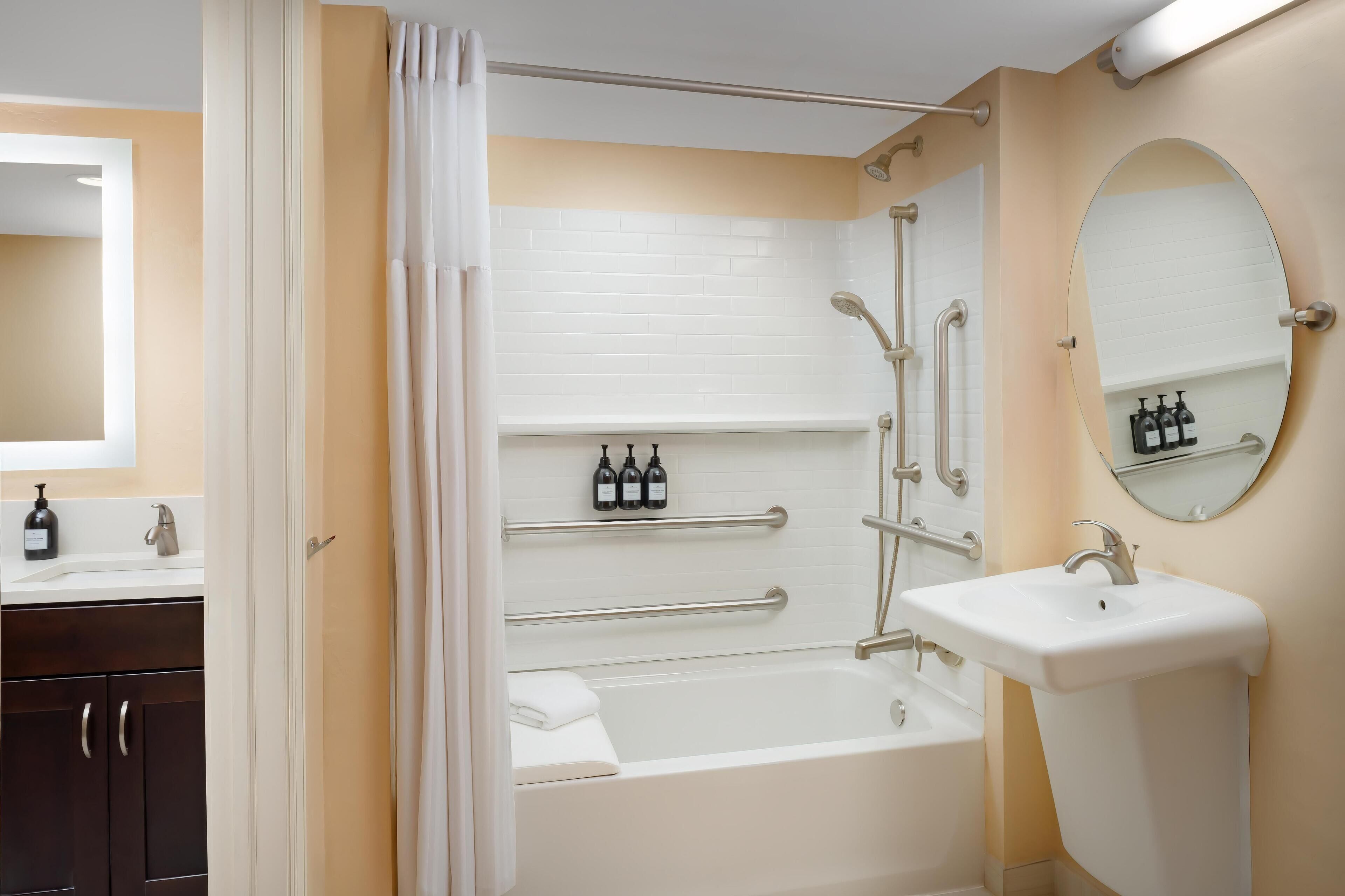 Un baño moderno con bañera, lavamanos y espejo.