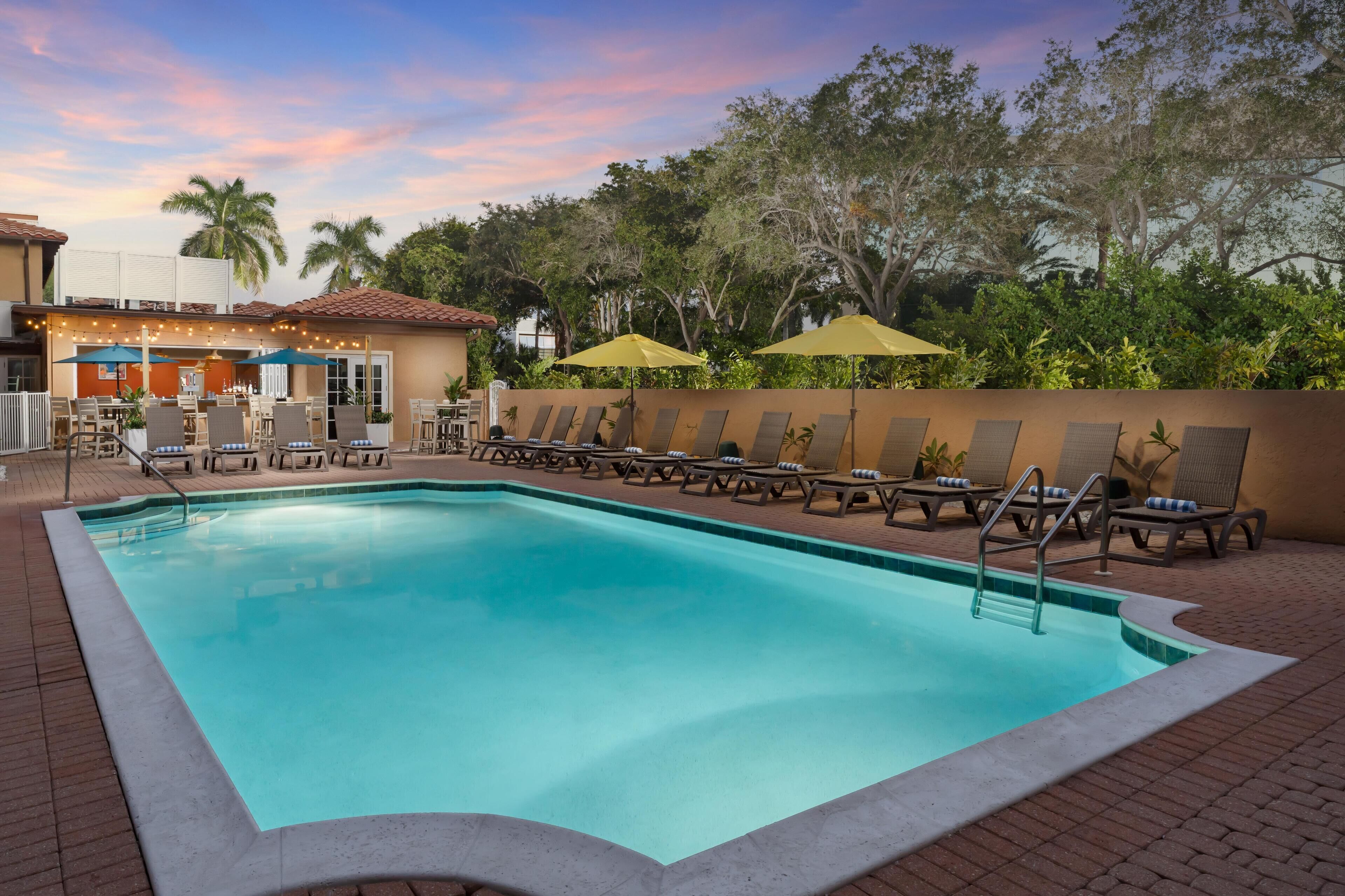 室外游泳池，提供泳池遮陽傘和日光浴躺椅