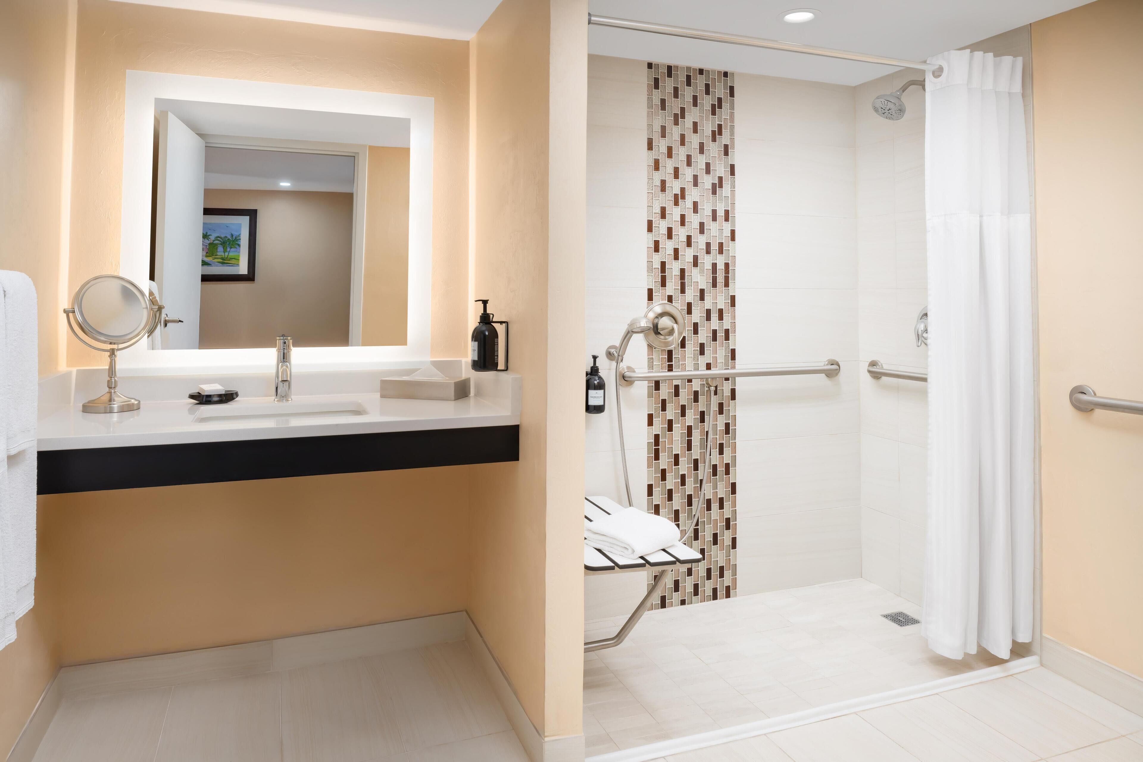 Ein modernes Badezimmer mit Waschbecken, Spiegel und Dusche.
