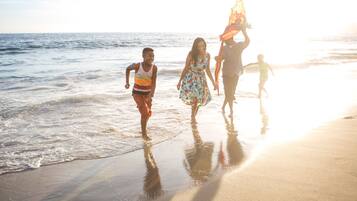 A beach scene with people walking along the shore.