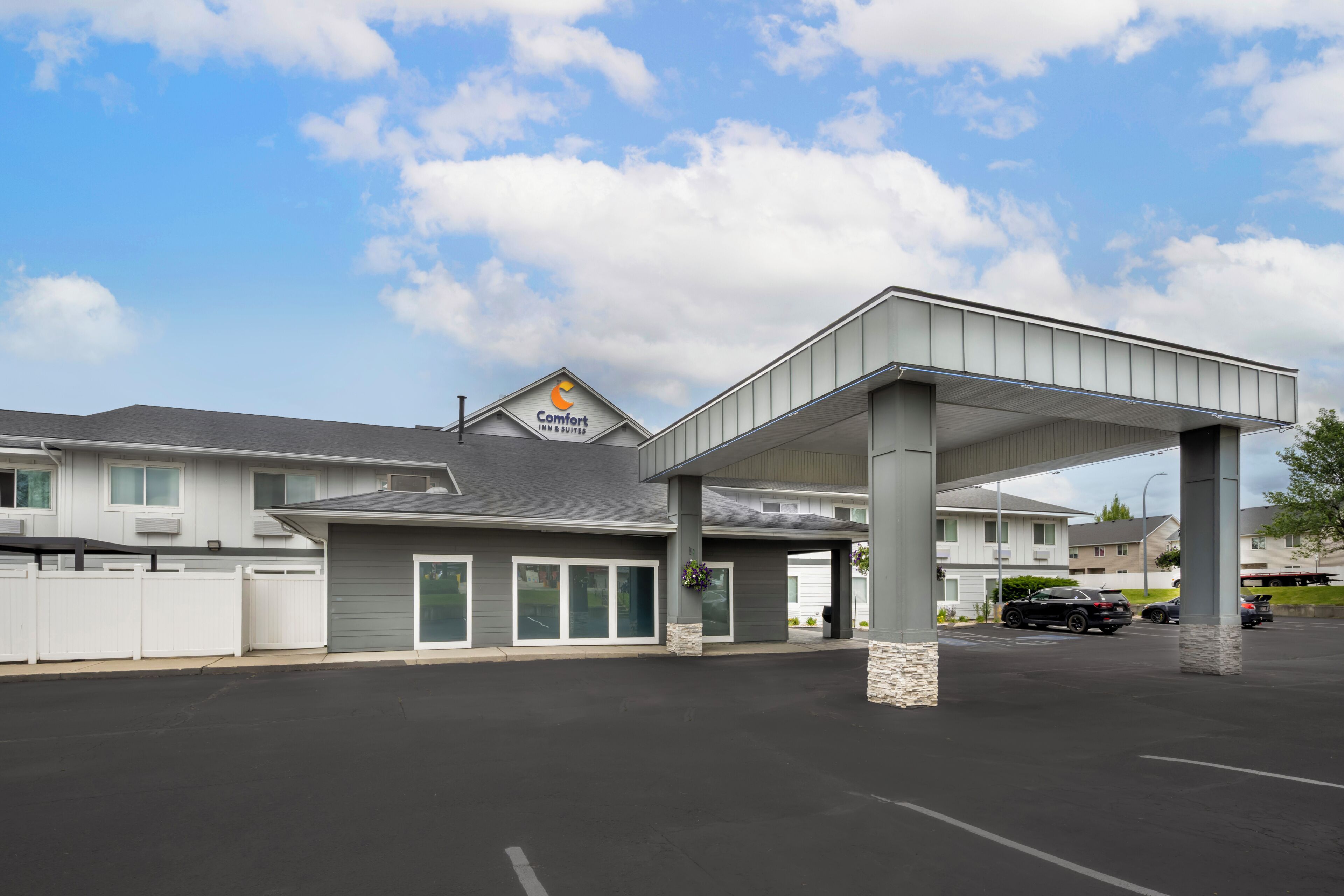 A Comfort Inn & Suites hotel with a covered parking area and a clear sky.