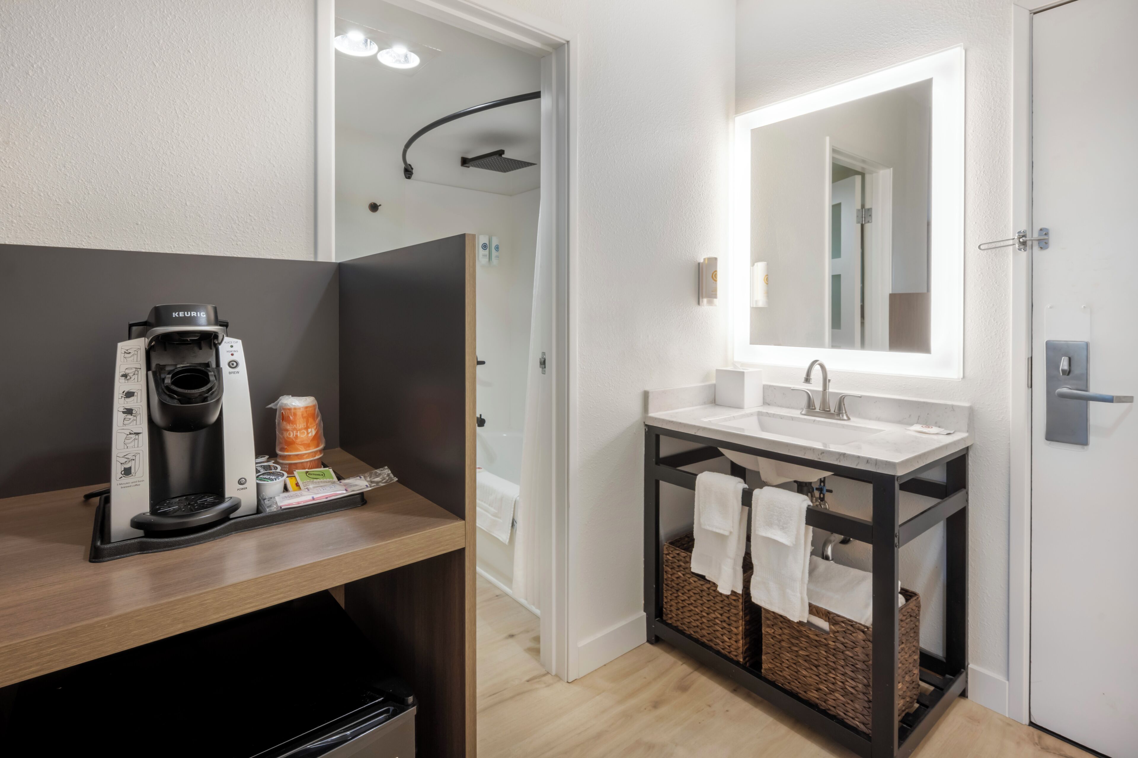 A modern bathroom with a shower, a coffee machine, and a sink.