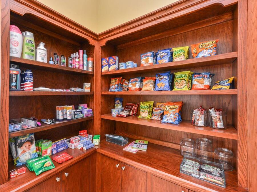 Un garde-manger bien organisé, avec des étagères remplies d’en-cas, de produits de toilette et d’articles ménagers.