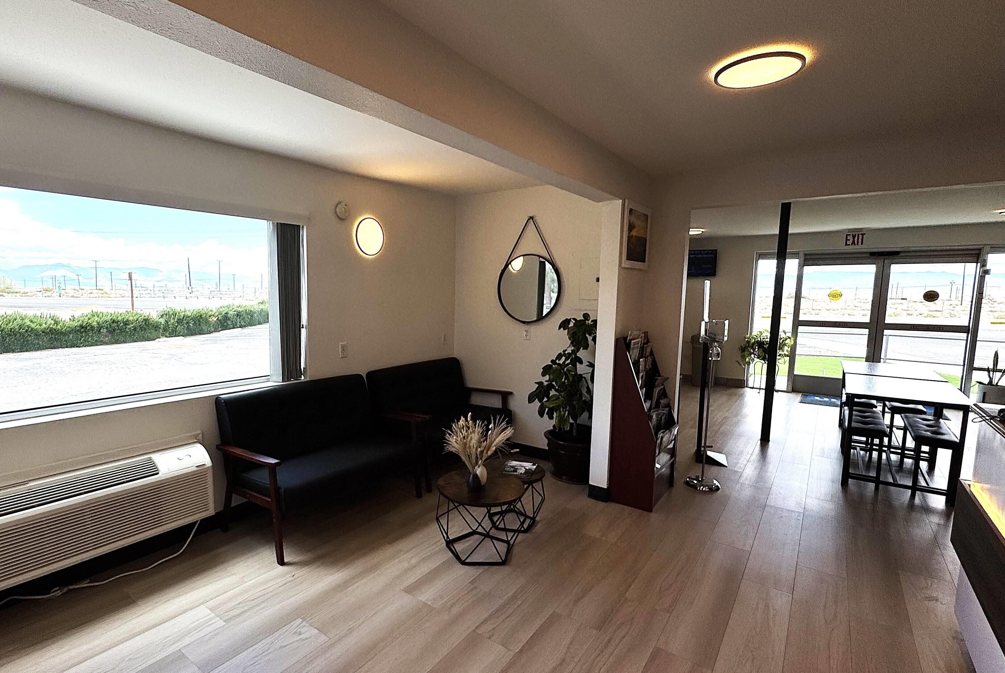 A modern interior with a sofa, a round coffee table, and a dining area with a table and chairs.