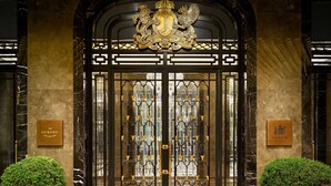 A grand entrance with a coat of arms, two plaques, and a symmetrical design.