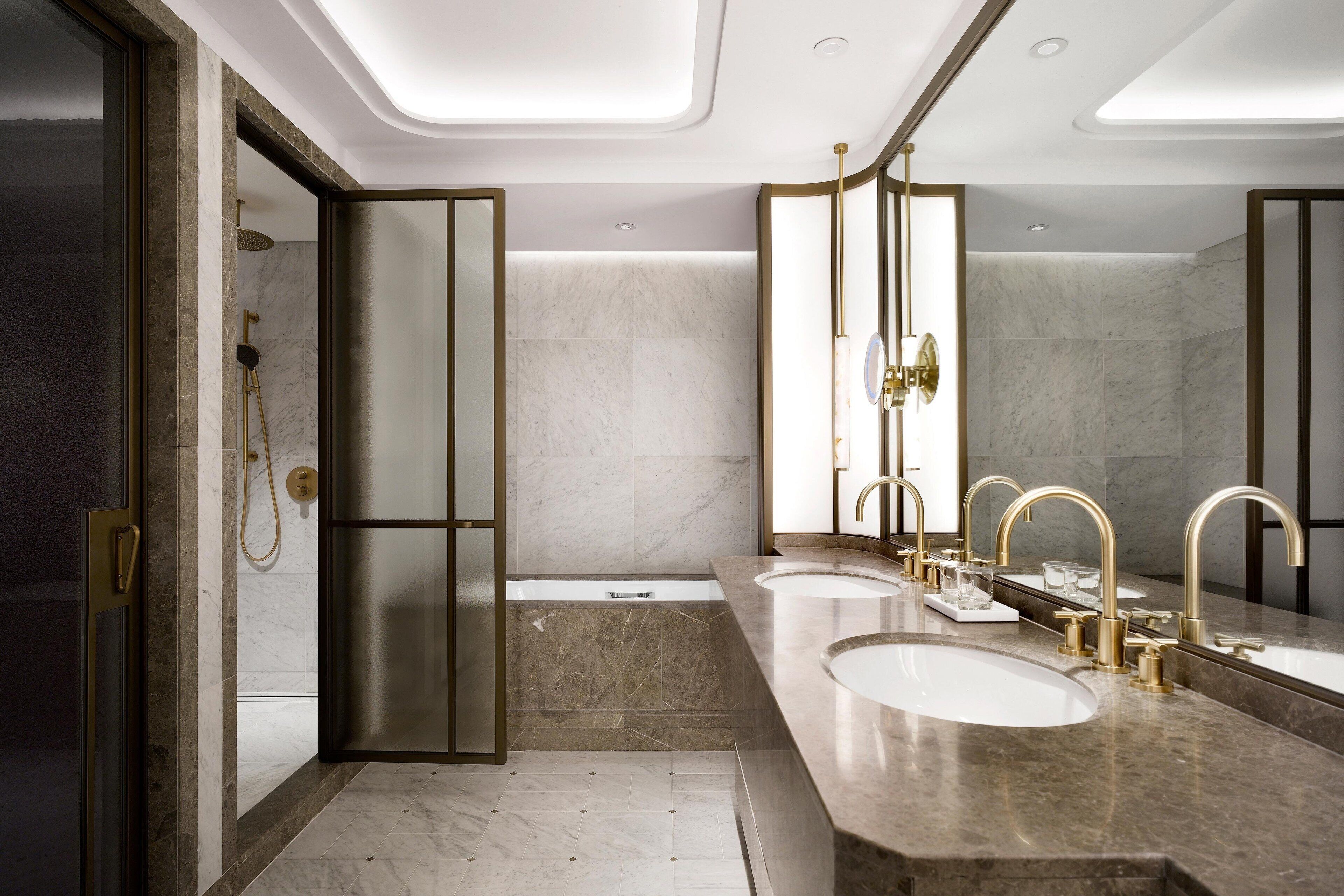 A modern bathroom with a double sink, a bathtub, and a shower.