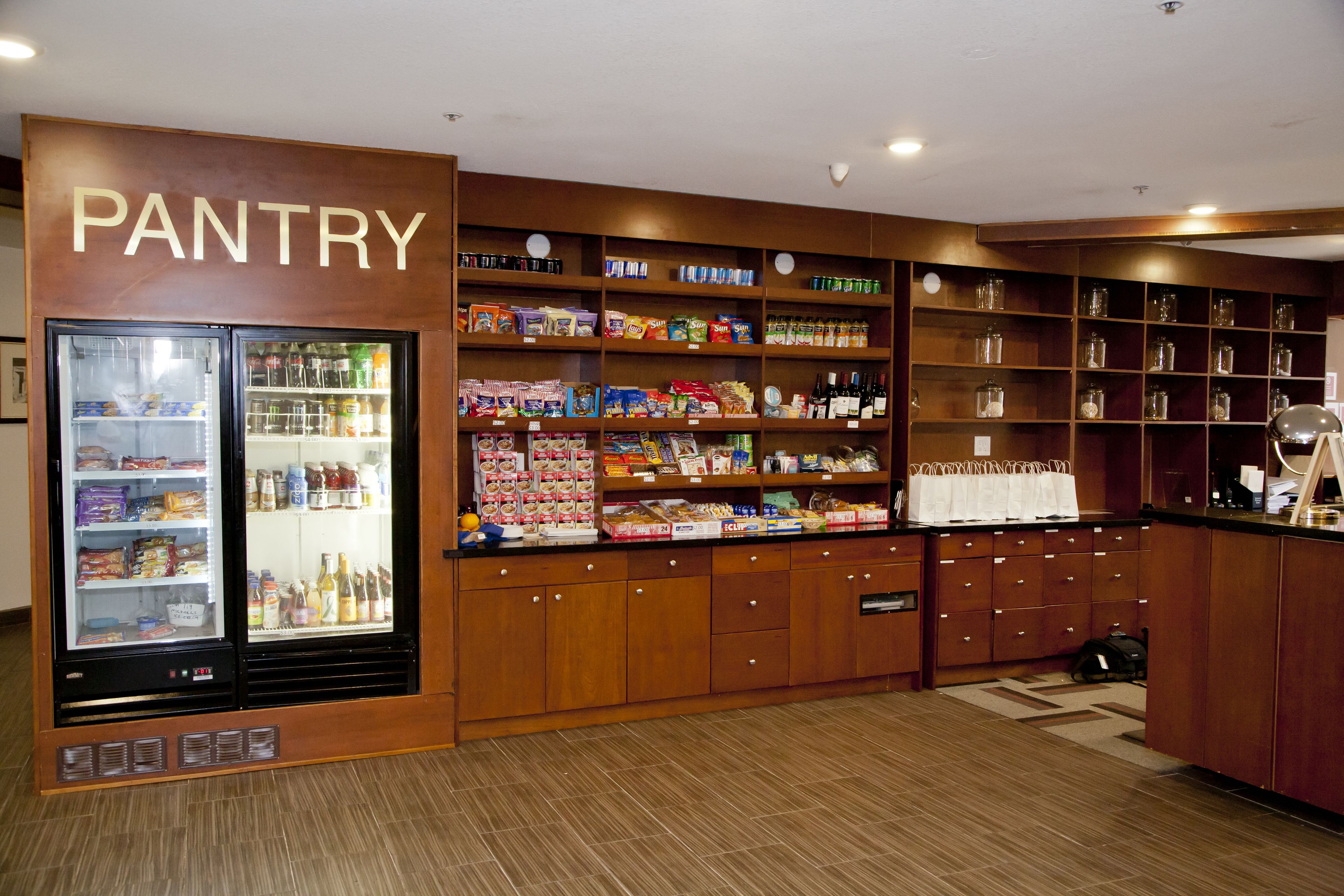 A pantry with shelves stocked with snacks, beverages, and other food items.