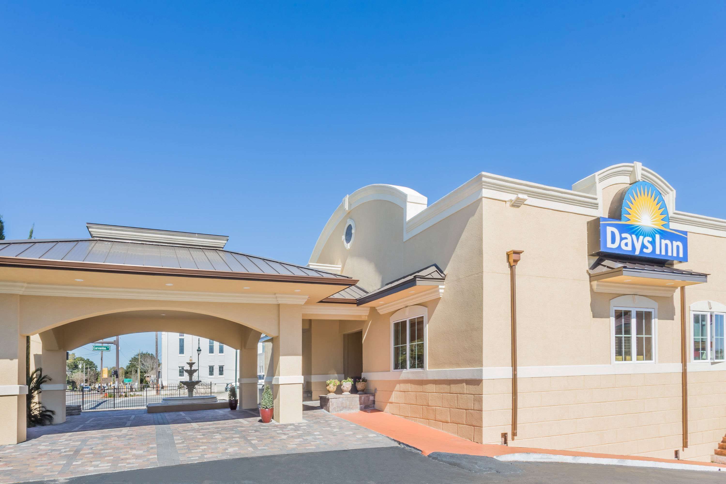 A Days Inn building with a clear entrance, a covered walkway, and a visible street sign.