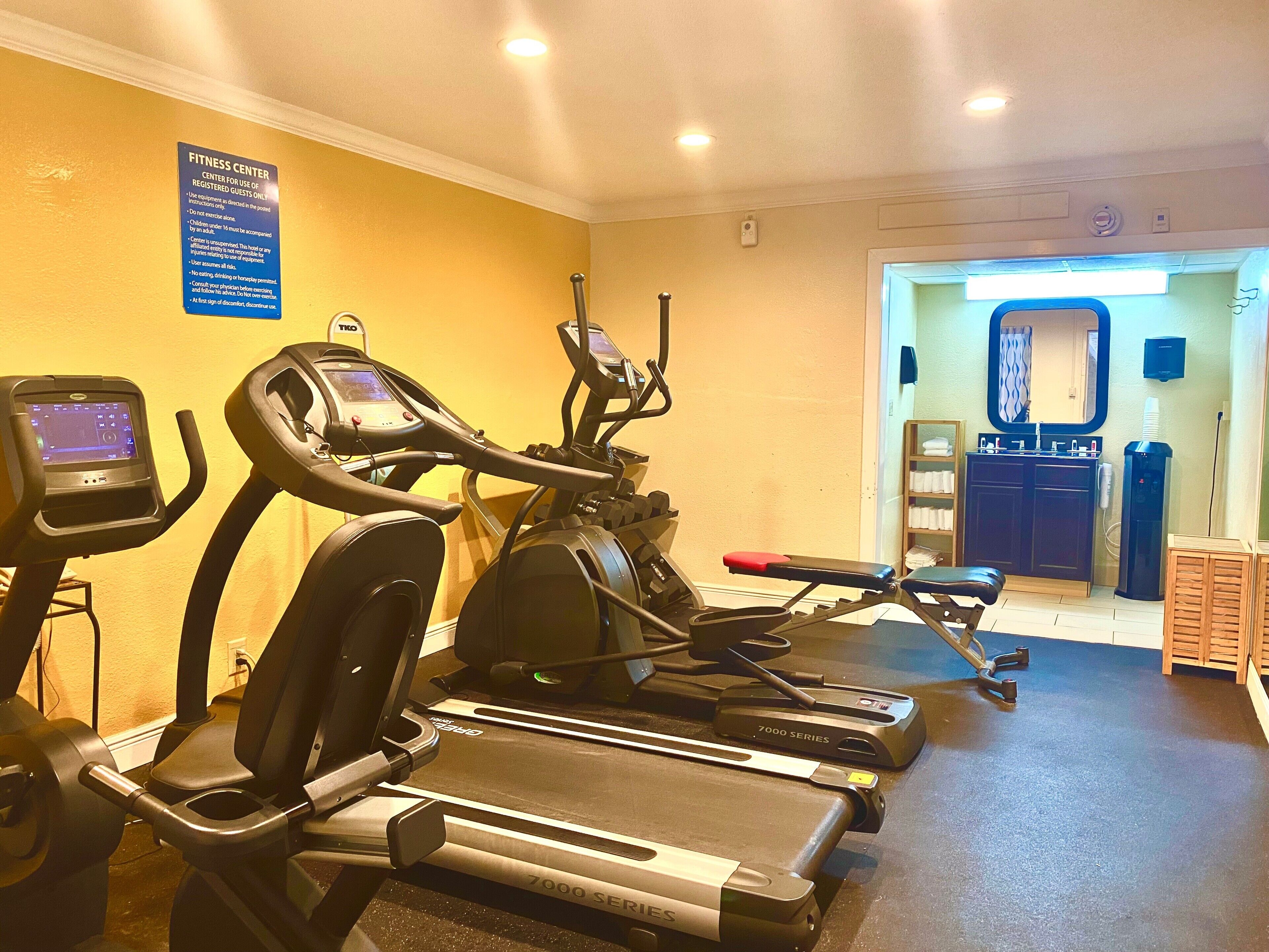 A fitness center with treadmills, a stationary bike, and a rowing machine.