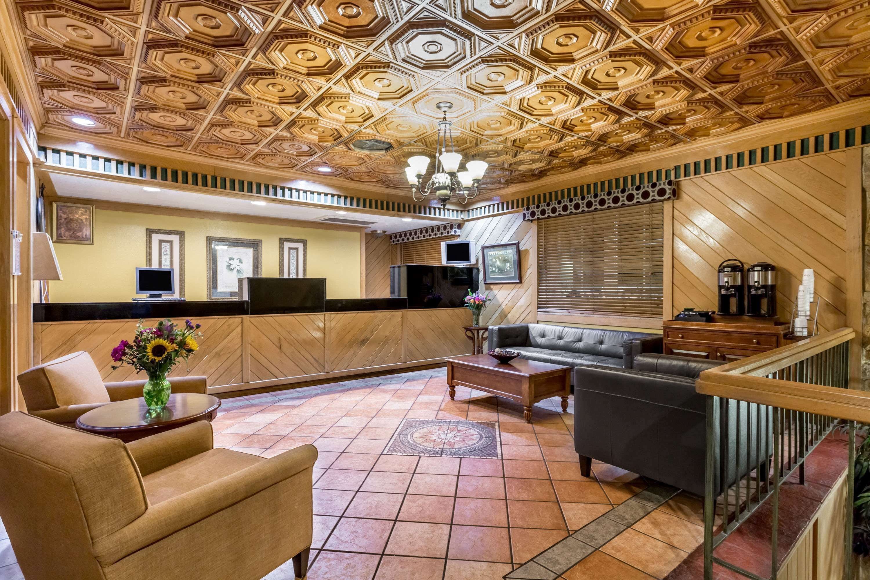 A hotel lobby with a wooden ceiling, a sofa, a coffee table, and a TV.