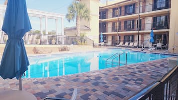 Piscine extérieure en saison, chaises longues
