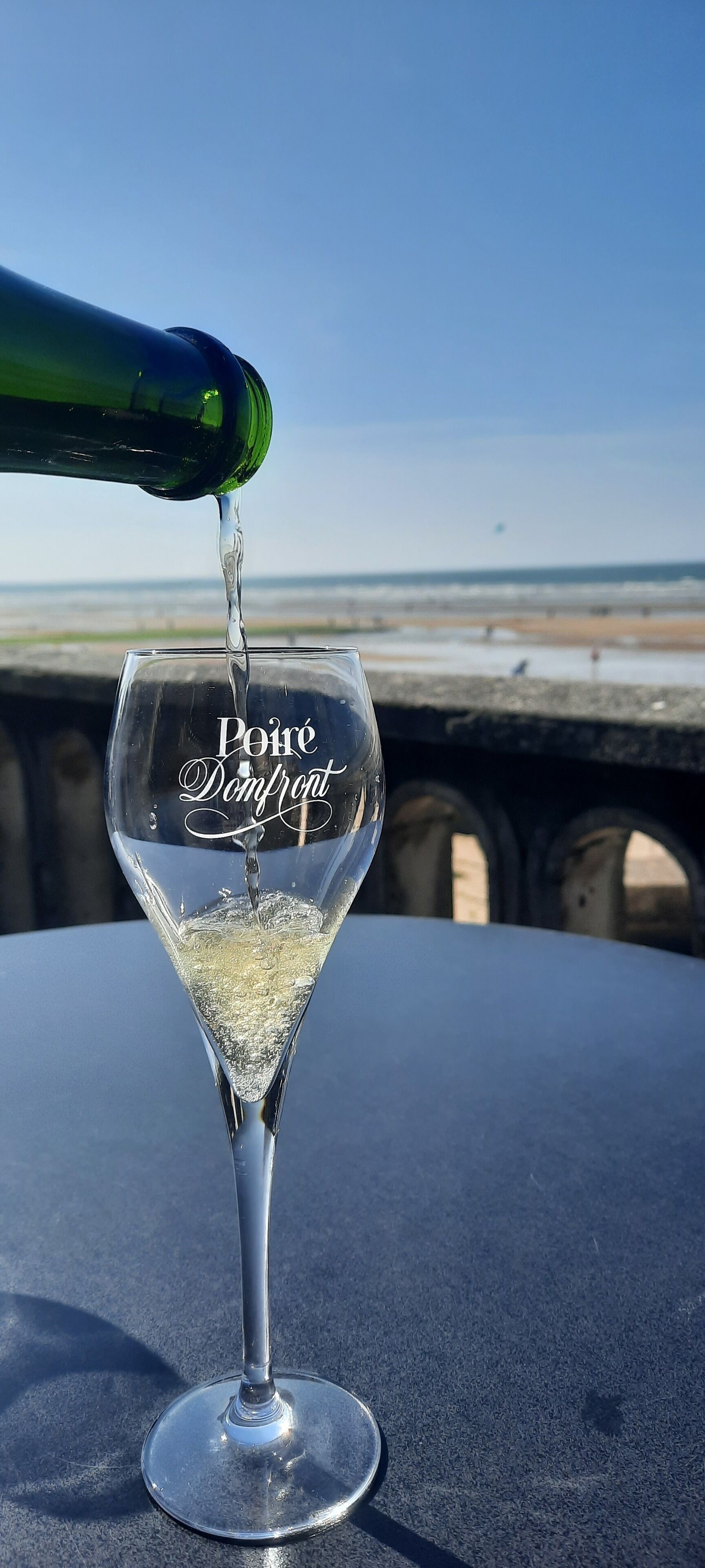 Un verre dans lequel on verse du « Poiré Domfront ».