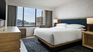 A hotel room with a large window, a bed, a desk, and a chair. - Sheraton Philadelphia University City Hotel (Philadelphia)