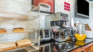 A breakfast counter with a coffee machine, toaster, and bread. - Econo Lodge Castro Valley I-580 (Castro Valley)
