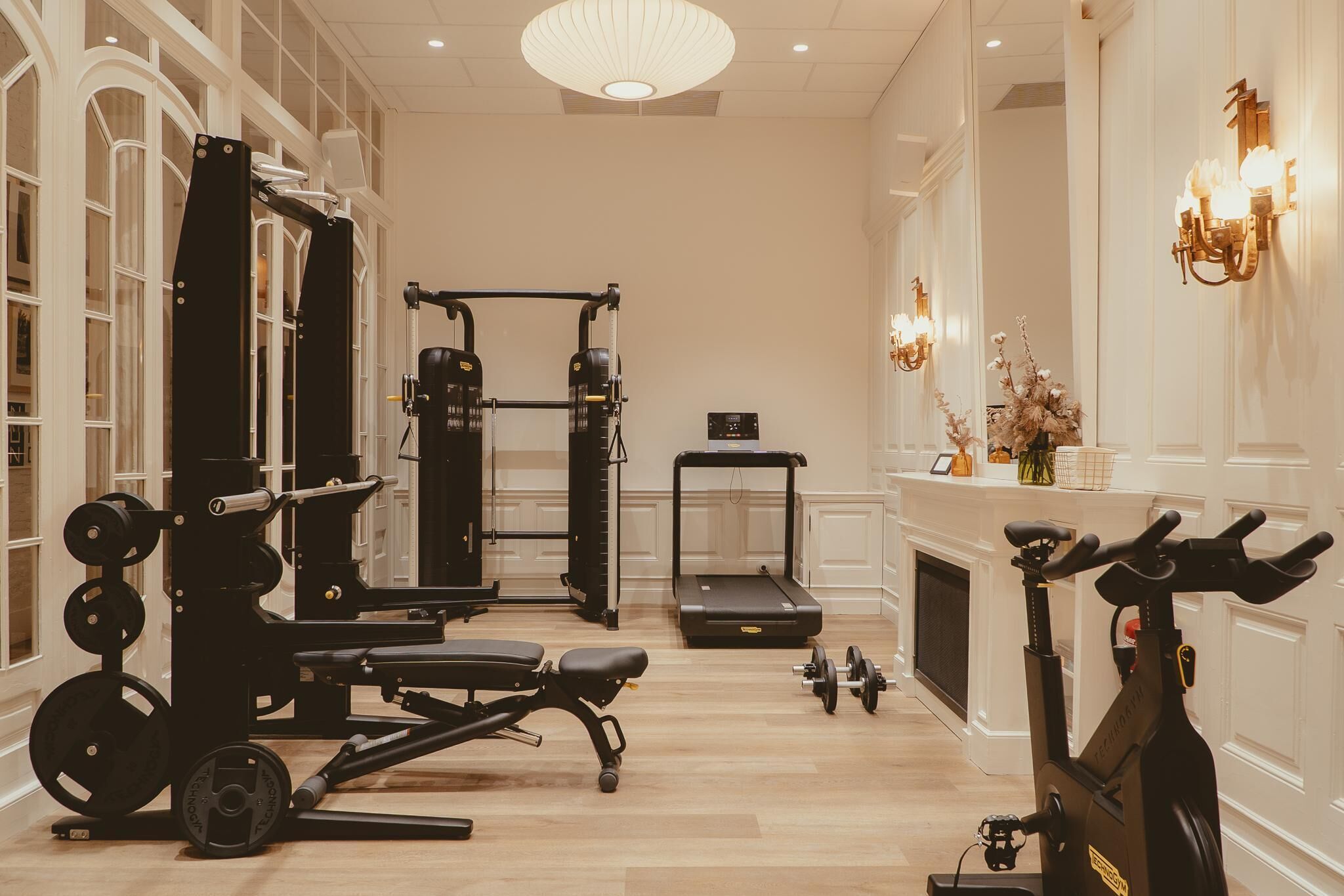 A gym with exercise equipment, a treadmill, and a stationary bike.