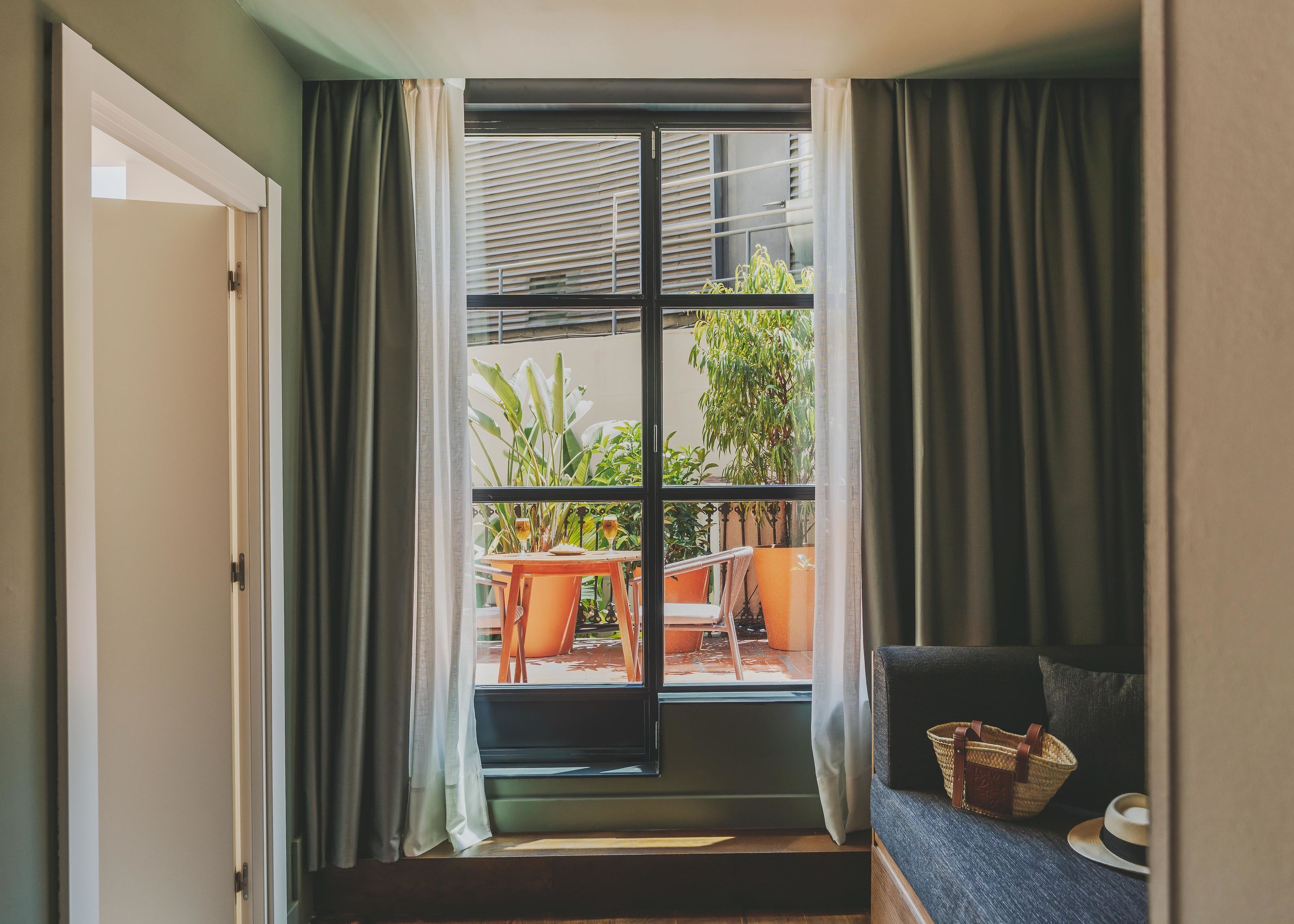 A room with a large window, a door, and a seating area with a table and chairs.