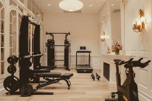 A gym with exercise equipment, a treadmill, and a stationary bike. - Hotel Regina Barcelona (Barcelona)