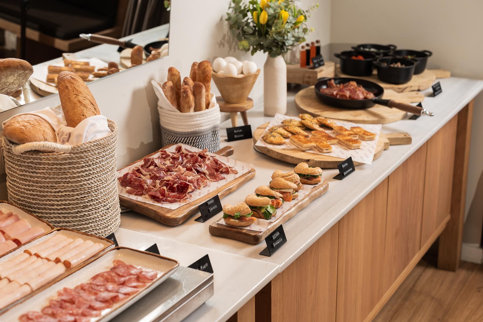 A buffet with various food items including bread, meats, and sandwiches.
