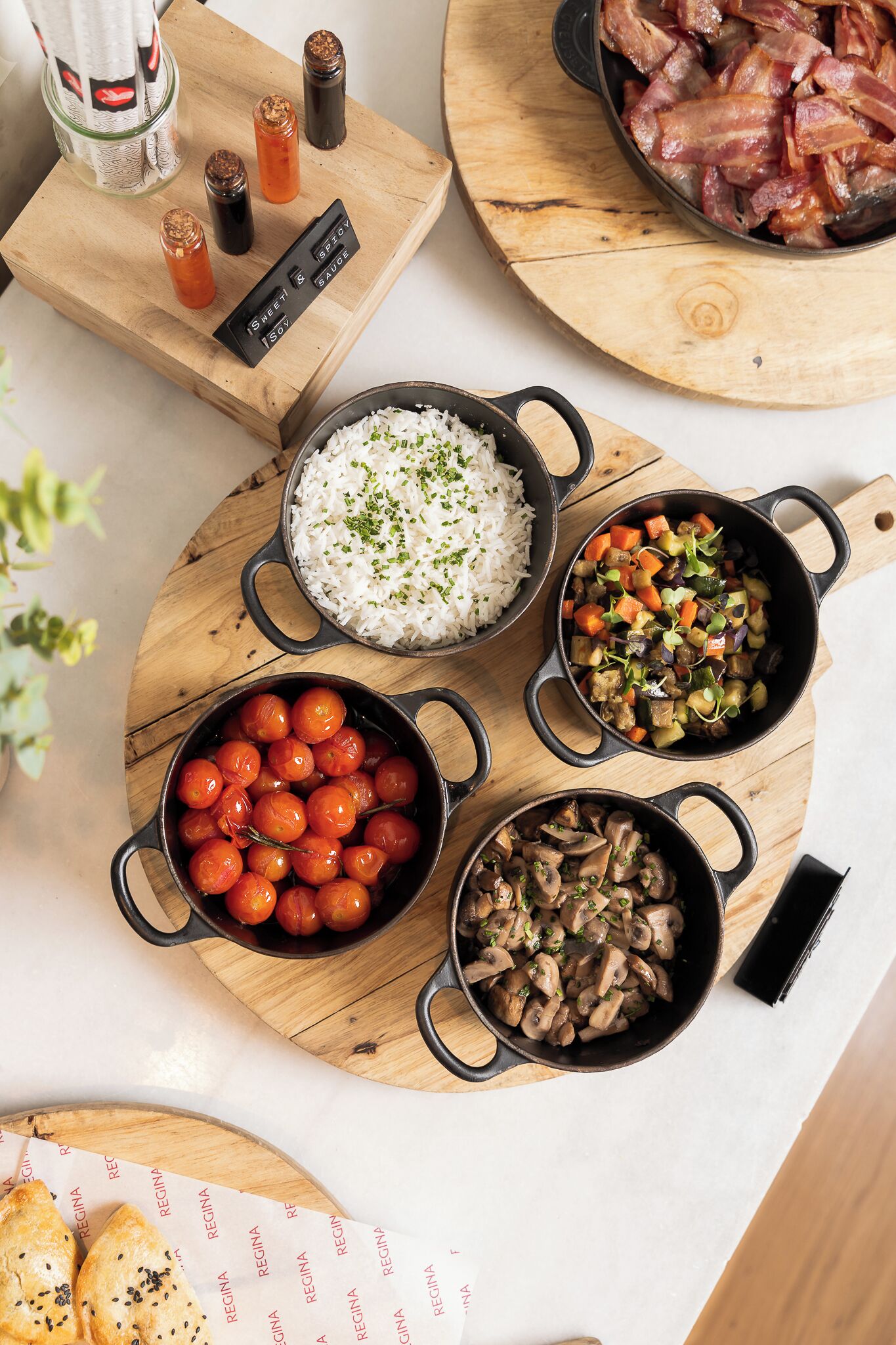 A wooden board with various dishes including rice, vegetables, and mushrooms.