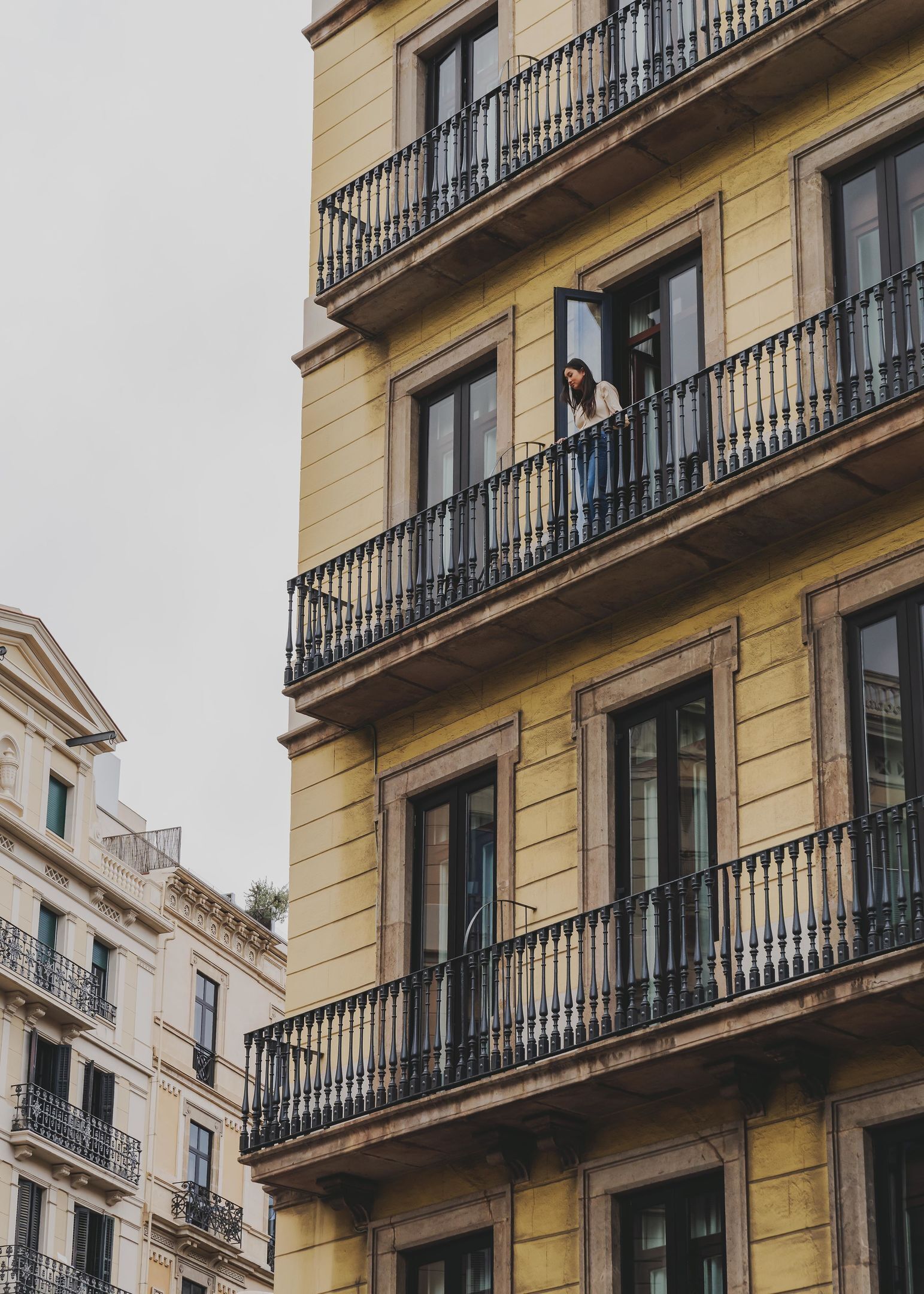 A multi-story building with balconies and large windows.